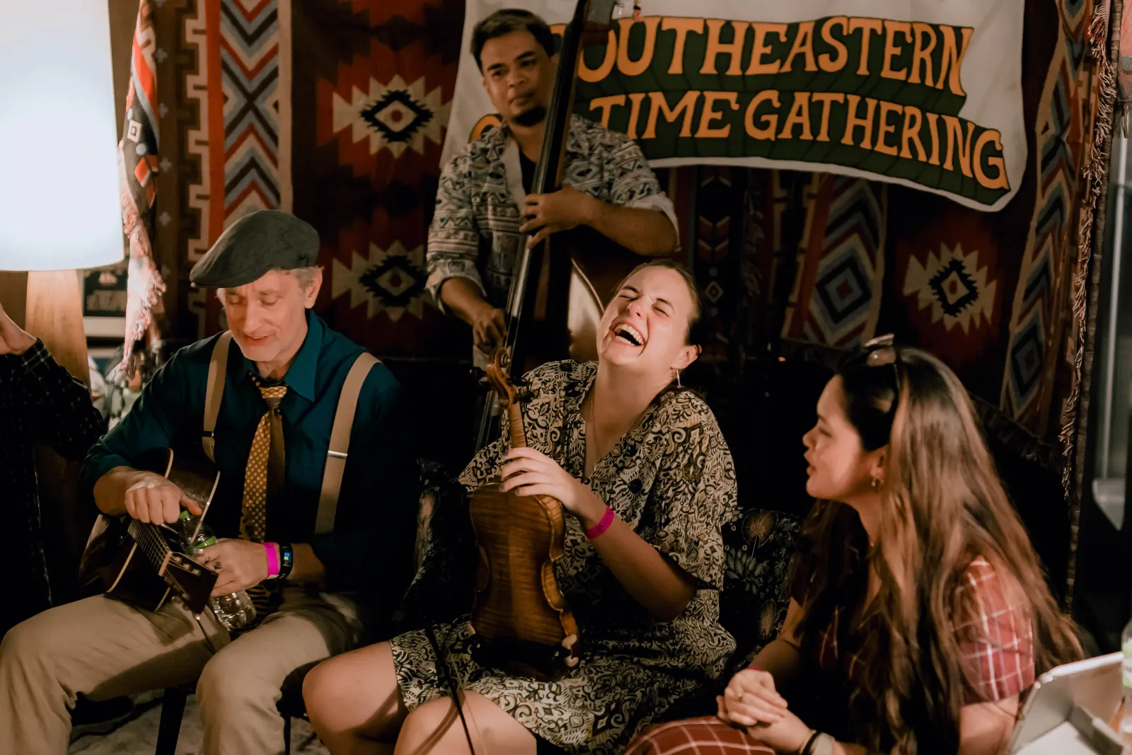 Musicians and friends laughing together inside an informal session