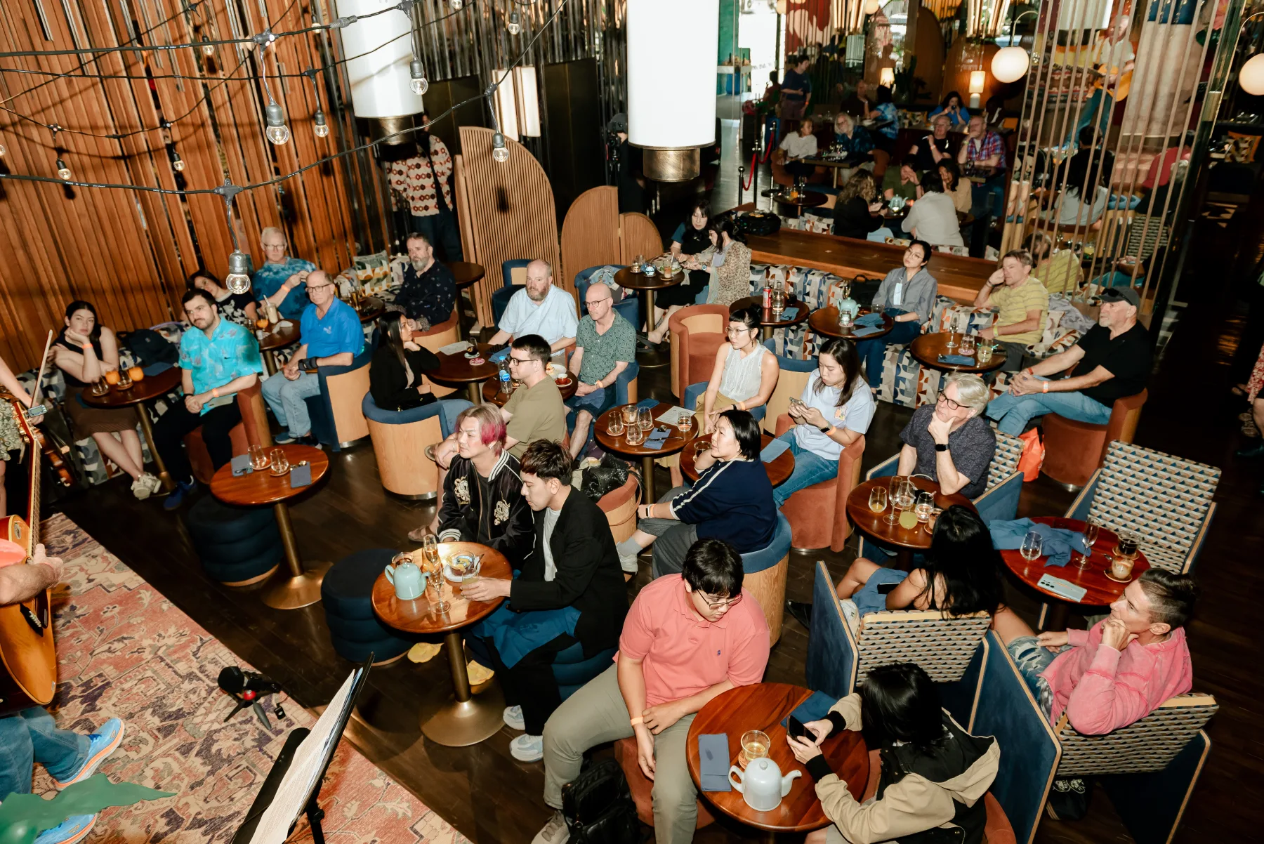 High-angle view across tables and a tightly packed Gathering audience