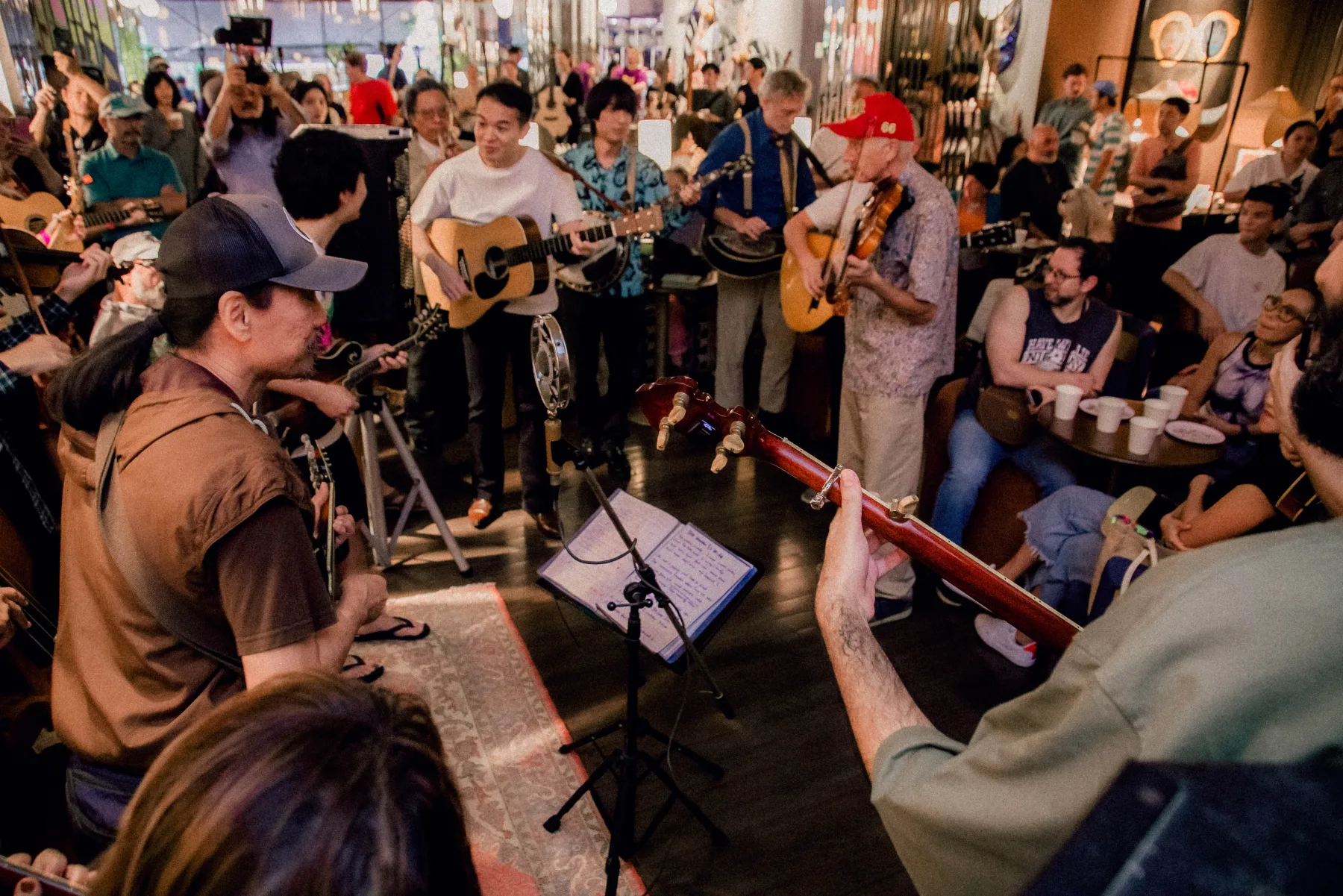 View from inside a crowded jam circle with instruments crossing the frame