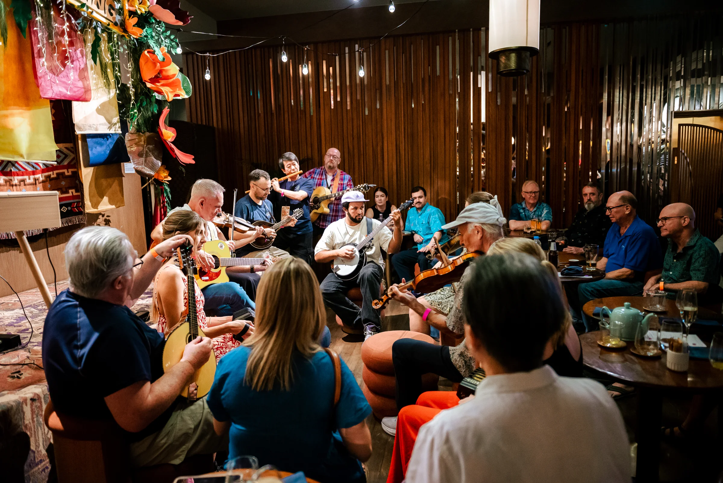 A wide circular session with musicians and listeners gathered closely together